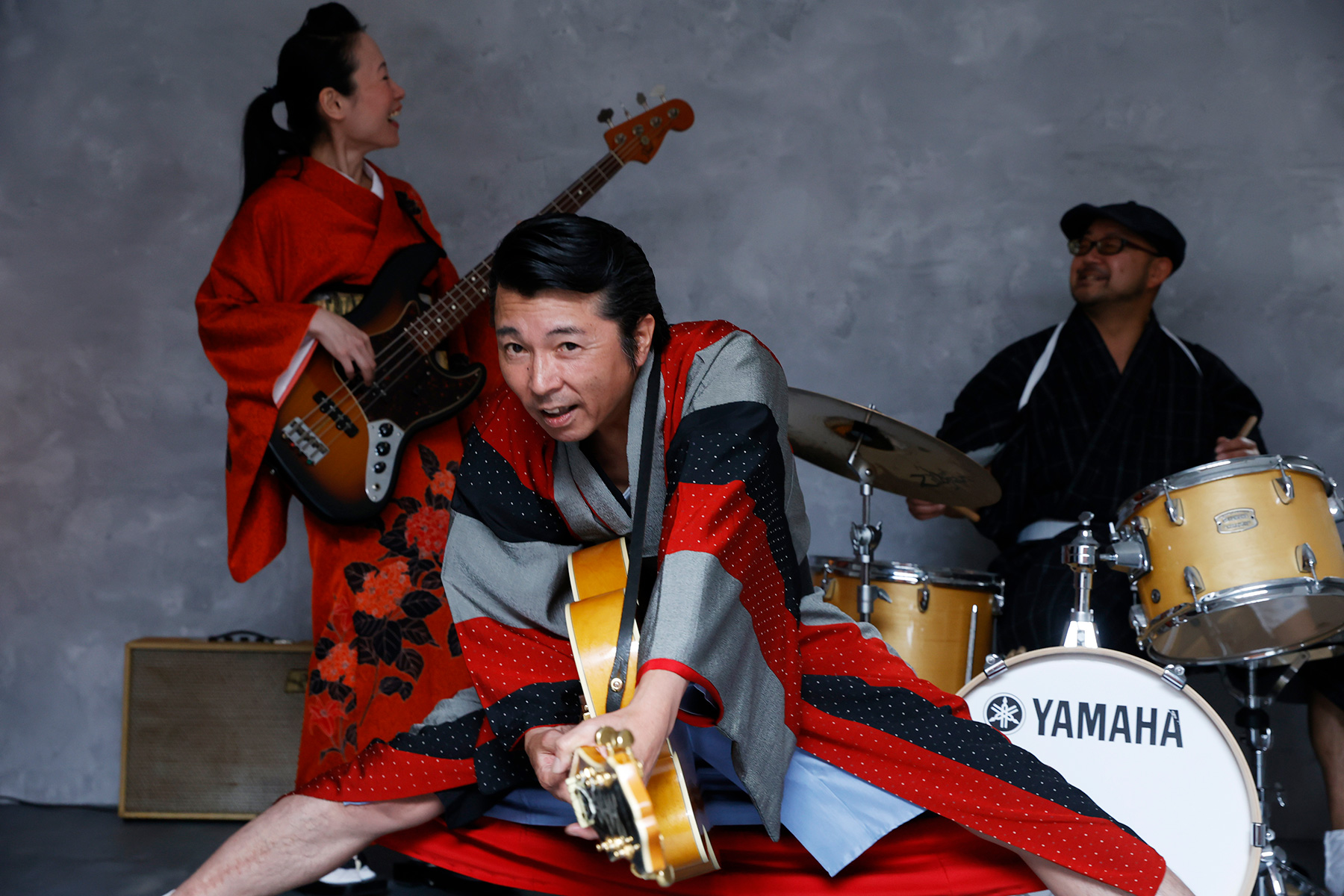 スタジオでの撮影、楽器を演奏する和装のバンド